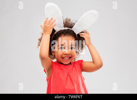 Felice bambina indossa coniglietto pasquale per le orecchie Foto Stock