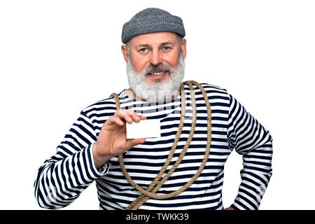 Foto sailor in una striped T-shirt. Un uomo di mezza età con una barba grigia è in possesso di un white white business card Foto Stock