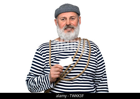 Foto sailor in una striped T-shirt. Un uomo di mezza età con una barba grigia è in possesso di un bianco business card Foto Stock