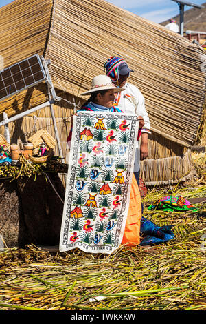 Fatte a mano artigianale di merci e prodotti tessili cuciti per la vendita su Isole Uros, reed isole galleggianti sul lago Titicaca, Perù, Sud America Foto Stock