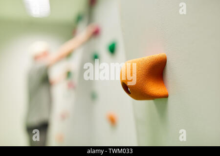 Grip su una parete di arrampicata per bouldering in un centro di arrampicata o nel centro fitness Foto Stock