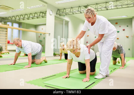 Fisioterapista dà dei cittadini anziani aiutare con esercizi per la schiena e la fisioterapia Foto Stock