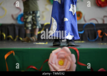 Dettagli con il mago vestito di un piccolo ragazzo ad esibirsi sul palco durante un kindergarten prom celebrazione. Foto Stock