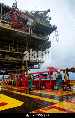 Equipaggio della nave sicuro di sicurezza personale cestello operare dal gruista durante il trasferimento piattaforma petrolifera equipaggio di nave. Foto Stock