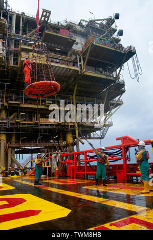 Equipaggio della nave sicuro di sicurezza personale cestello operare dal gruista durante il trasferimento piattaforma petrolifera equipaggio di nave. Foto Stock