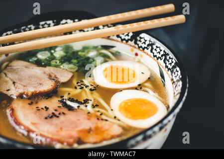 Ramen zuppa di Udon Noodles, carne di maiale e uova su sfondo scuro Foto Stock