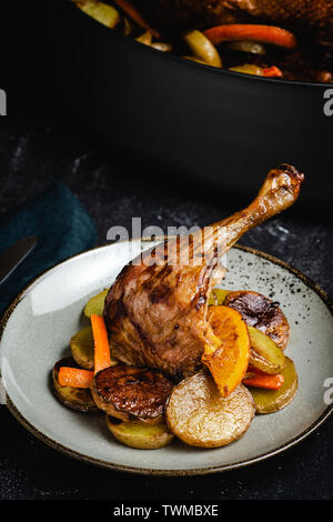 Arrosto di Pollo gamba piatto con patate, carote e arance Foto Stock