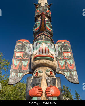 Sett. 17, 2018 - Ketchikan, AK: Colorful Raven e nebbia donna scolpiti abbassare il capo della sezione di Johnson Totem Pole con chiaro cielo blu scuro. Foto Stock