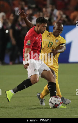 Il Cairo, Egitto. Il 21 giugno, 2019. Dell'egitto Mahmoud Hassan 'Trezeguet' (L) e Zimbabwe la conoscenza Musona battaglia per la sfera durante il 2019 Africa Coppa delle Nazioni di una partita di calcio tra Egitto e Zimbabwe a Il Cairo International Stadium . Credito: Oliver Weiken/dpa/Alamy Live News Foto Stock