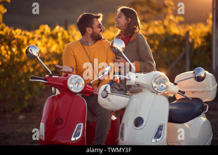 Coppia giovane su scooter godendo in viaggio sulla strada romantica. Foto Stock