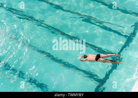 L'uomo saltare ad una piscina esterna a Sydney in Australia Foto Stock