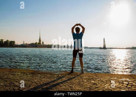 Giovane uomo facendo esercizi sulla freccia sullo sfondo della fortezza di Pietro e Paolo. San Pietroburgo. L'estate. Mattina. (Irriconoscibile persona) Foto Stock