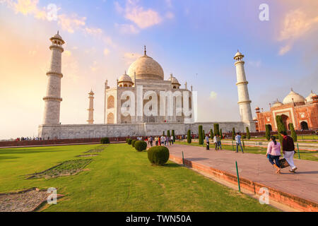 Taj Mahal storico mausoleo di marmo al tramonto con vista di turisti che si godono la vista a Agra, India Foto Stock