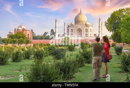 Taj Mahal scenic vista tramonto da Mehtab Bagh con tourist giovane godendo della vista Foto Stock