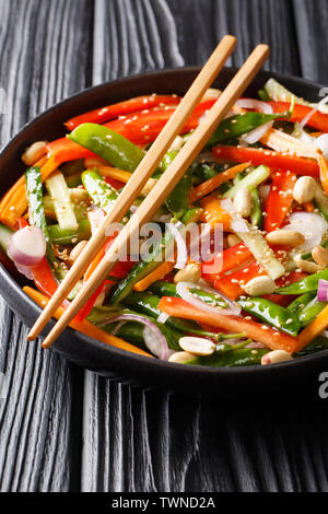 Il cinese fresca insalata di verdure con sesamo e arachidi close-up su una piastra sul piano verticale. Foto Stock