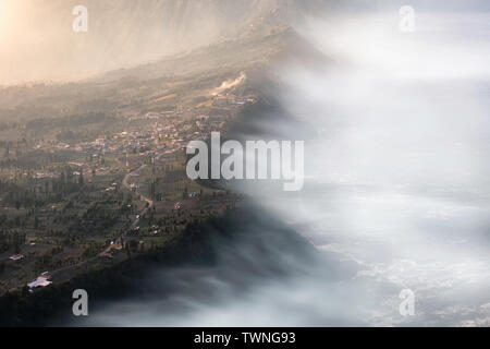 Cemoro Lawang villaggio sulla scogliera di montagna con la nebbia a sunrise. Bromo tengger semeru national park, East Java, Indonesia Foto Stock