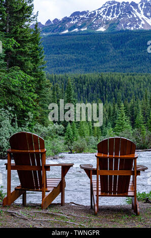 2 posti in legno Sedie Adirondack comprare un fiume nelle Montagne Rocciose Canadesi Foto Stock