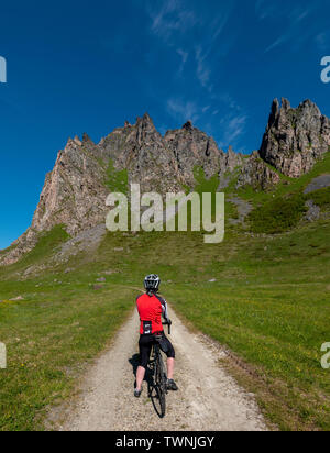 Ciclista femmina a cavallo da Bleik a Andenes, Vesteralen, Andoya, Norvegia. Foto Stock