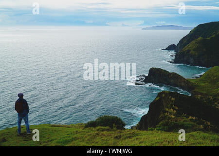 Il viaggiatore a piedi la parte nord della Nuova Zelanda a Cape Reinga e guardando l'oceano Foto Stock