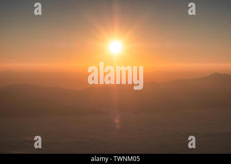 Sole che splende su orizzonte con montagna in mattinata Foto Stock