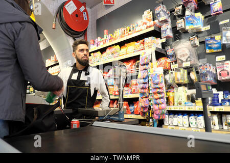 Giovane lavoratore di sesso maschile lavora alla cassa di un negozio di alimentari e il cliente alla cassa in Lisbona Portogallo Europa KATHY DEWITT Foto Stock