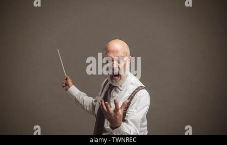 Senior professore autoritario urla e indicando la lavagna con un bastone: tradizionale concetto di istruzione Foto Stock