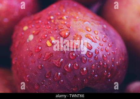 Gocce di acqua su un rosso sfondo apple Foto Stock