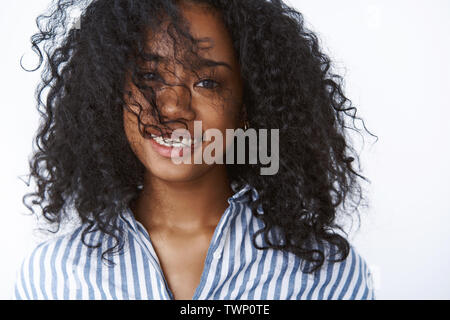 Il benessere e la felicità del concetto. Carefree attraente quartiere alla moda di carnagione scura donna, curly-haired sorridente gioioso ampiamente godendo impressionante giornata positiva-off Foto Stock