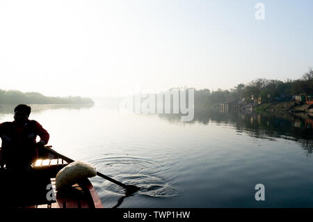 Silhouette di boatsman remare nella yamuna ganga river al mattino. La mattina presto giri in barca sul santo fiumi sacri dell India sono un comune Foto Stock