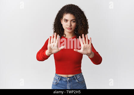 Fermatevi qui non più. Grave-guardando fiduciosi donna forte femenist combattimenti pari diritti impegnativo tenere tratto palms tabù mettere in guardia gesto look s Foto Stock