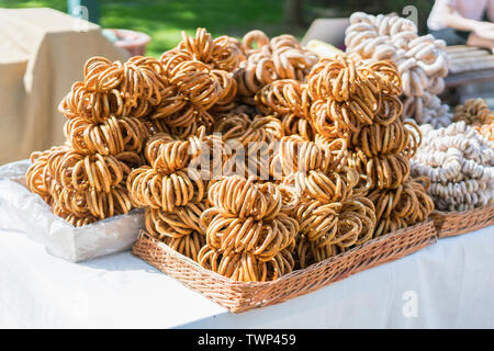 Asciugare i bagel heap, messa a fuoco selettiva. Bagel con semi di papavero in negozio. Foto Stock