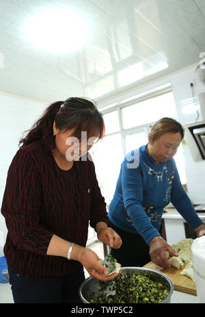 (190622) -- YINCHUAN, 22 giugno 2019 (Xinhua) -- abitante Sun Jinhua (L) e la madre-in-legge preparare il pranzo presso la loro nuova casa in Xingwuying villaggio di Yanchi County, a nord-ovest della Cina di Ningxia Hui Regione autonoma, 27 maggio 2019. Situato sul bordo meridionale del deserto Maowusu, Yanchi contea era una volta colpito dalla povertà e ha sofferto di desertificazione. Ma dopo anni di sforzi, l'ambiente vi è stata ripristinata e la contea ha scosso anche fuori dalla povertà. (Xinhua/Zheng Wei) Foto Stock