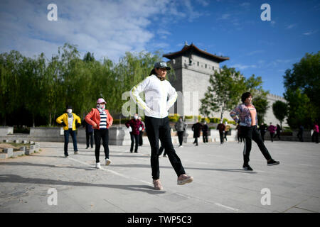 (190622) -- YINCHUAN, 22 giugno 2019 (Xinhua) -- cittadini esercizio vicino alla città di rinnovato parete in Yanchi County, a nord-ovest della Cina di Ningxia Hui Regione autonoma, 28 maggio 2019. Situato sul bordo meridionale del deserto Maowusu, Yanchi contea era una volta colpito dalla povertà e ha sofferto di desertificazione. Ma dopo anni di sforzi, l'ambiente vi è stata ripristinata e la contea ha scosso anche fuori dalla povertà. (Xinhua/Wang Peng) Foto Stock