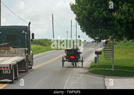 Carrello passante un buggy oltre solido doppia linea gialla sulla strada di un paese in Pennsylvania, STATI UNITI D'AMERICA Foto Stock