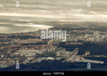 Capitale portoghese Lisbona da sopra. Skyline della città con le nuvole nel cielo. Edifici e la foce del fiume Tejo nome con il paesaggio e le navi sul Foto Stock