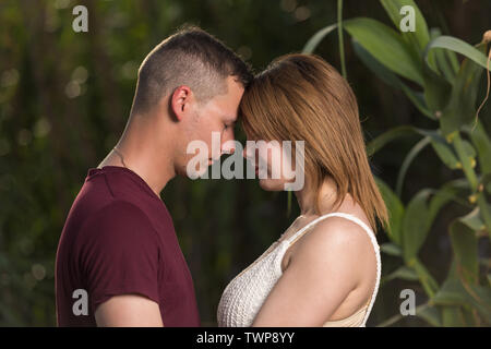 Amare l uomo e la donna felice in una molla parco fiorito. Felice Coppia matura in amore abbracciando outdoor Foto Stock