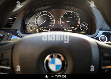 Grodno, Bielorussia, 16 Maggio 2013: cruscotto elettronico di lusso moderno BMW 750Li XDrive auto con ruota al di fuori della messa a fuoco con il logo BMW. Foto Stock