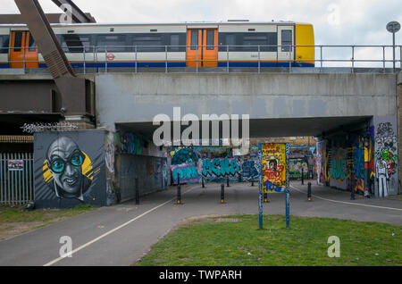 Un London Overground treno passa sopra un ponte sulla Pedley Street che mostra la rigenerazione della zona in Spitalfields con migliori collegamenti di trasporto Foto Stock