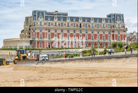 21 giugno 2019, France (Francia), Biarritz: una scavatrice pale sabbia sulla spiaggia di fronte all'Hotel du Palais. Il prossimo vertice G7 si svolgerà qui dal 24.08.2019 - 26.08.2019 e saranno ospitati in Francia. L'edificio sarà ampiamente rinnovato in vista del vertice. Foto: Frank Rumpenhorst/dpa Foto Stock