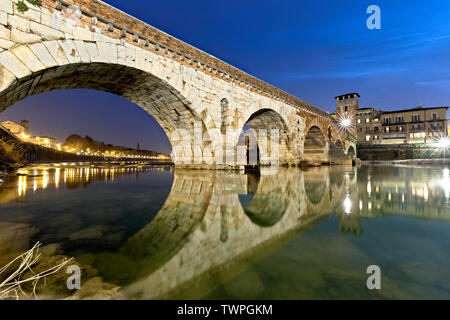 Gli archi del Ponte di Pietra sono riflessi nel fiume Adige. Verona, Veneto, Italia, Europa. Foto Stock