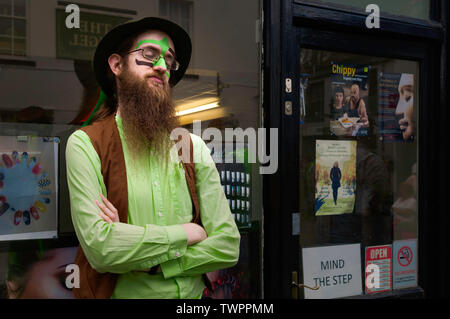 Una Morris ballerino è abiti colorati e sporting una barba folta prende un breve riposo tra le prestazioni in Beverley, Yorkshire, Regno Unito. Foto Stock