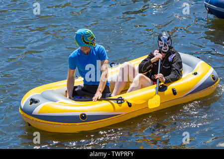 Iford, Dorset, Regno Unito. Il 22 giugno 2019. Il tempo era perfetto, caldo e soleggiato, ancora per Dorset Dinghy giorno con centinaia di gommoni, canotti pneumatici, artigianato, tavole che formano una flottiglia di salpare da ponte Iford giù il fiume Stour a ponte Tuckton. L'evento iniziato nel 2014 come un po' di divertimento, ma ora è diventato un evento annuale la raccolta di fondi per la carità ed il getter più grande di ogni anno. Due uomini che indossano maschere in gommoni gonfiabili. Credito: Carolyn Jenkins/Alamy Live News Foto Stock