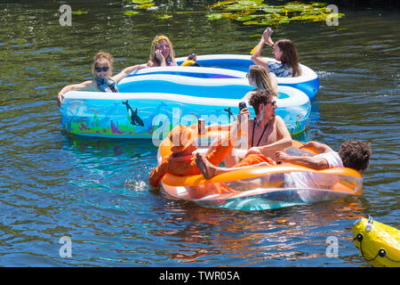 Iford, Dorset, Regno Unito. Il 22 giugno 2019. Il tempo era perfetto, caldo e soleggiato, ancora per Dorset Dinghy giorno con centinaia di gommoni, canotti pneumatici, artigianato, tavole che formano una flottiglia di salpare da ponte Iford giù il fiume Stour a ponte Tuckton. L'evento iniziato nel 2014 come un po' di divertimento, ma ora è diventato un evento annuale la raccolta di fondi per la carità ed il getter più grande di ogni anno. Amici divertendosi in lettini gonfiabili piscina gonfiabili. Credito: Carolyn Jenkins/Alamy Live News Foto Stock