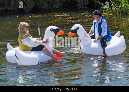 Iford, Dorset, Regno Unito. Il 22 giugno 2019. Il tempo era perfetto, caldo e soleggiato, ancora per Dorset Dinghy giorno con centinaia di gommoni, canotti pneumatici, artigianato, tavole che formano una flottiglia di salpare da ponte Iford giù il fiume Stour a ponte Tuckton. L'evento iniziato nel 2014 come un po' di divertimento, ma ora è diventato un evento annuale la raccolta di fondi per la carità ed il getter più grande di ogni anno. Donne divertendosi in Swan gonfiabile gonfiabili. Credito: Carolyn Jenkins/Alamy Live News Foto Stock