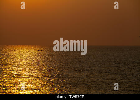 Una canoa con i pescatori all'alba sul lago Foto Stock