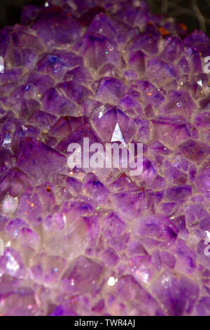 Viola quarzo ametista vista ravvicinata, ametista geode naturale gemma di cristallo di ripresa macro sfondo viola con effetto bokeh di fondo Foto Stock