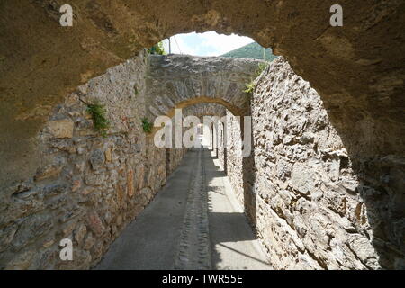 Passaggio sotto gli archi in pietra all'interno del borgo fortificato di Villefranche de Conflent, Pirenei orientali, Occitanie, Francia