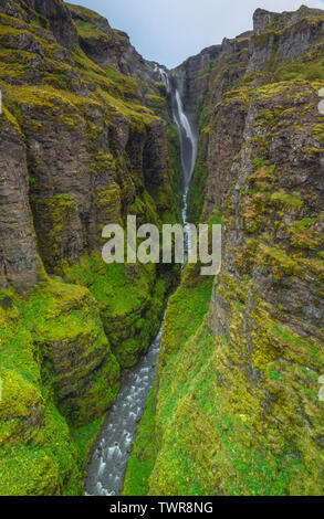 Punto di vista sulla parte superiore del bordo del canyon Glymur affacciato Glymur cade, alta cascata a cascata verso il basso un profondo canyon in Islanda. Foto Stock