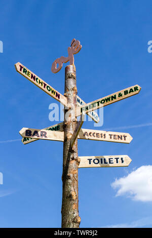 Un dito di legno post o marcatore di modo di dare indicazioni all'Africa Oye music festival di Sefton Park, Liverpool, Merseyside, Regno Unito Foto Stock