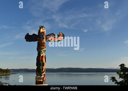 Un totem pole (con aquila e orso) al porto di Fiume di potenza, Canada Foto Stock